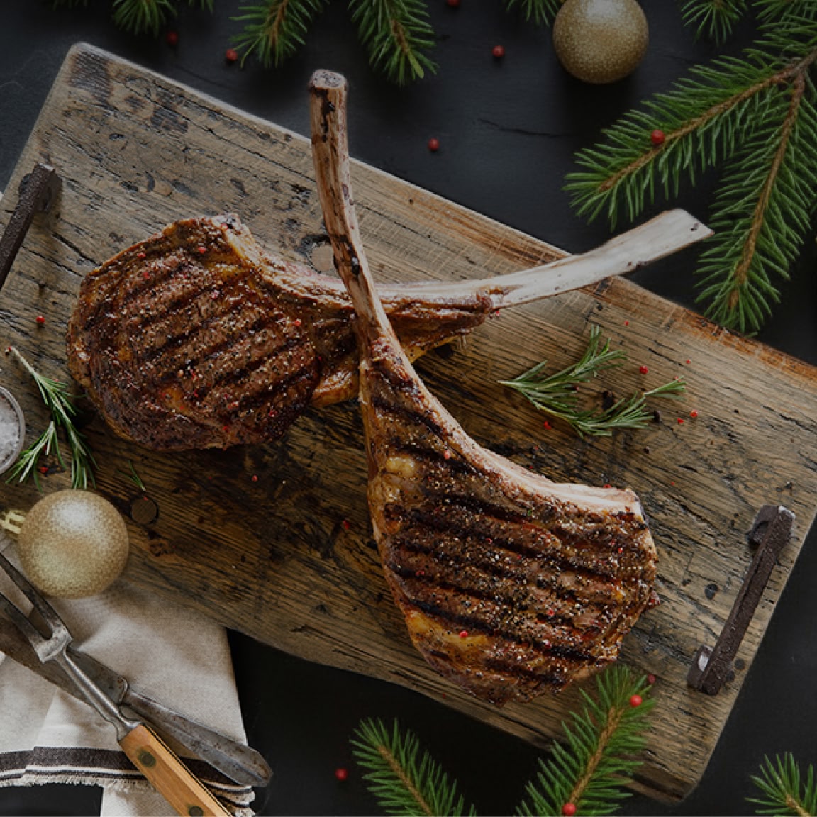 grilled tomahawk bone-in steaks ona cutting board